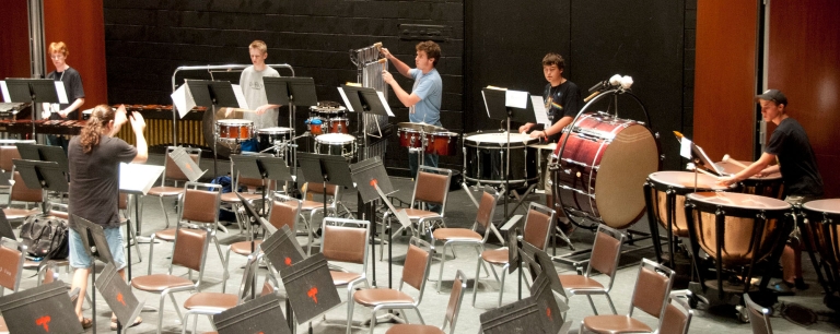 Percussion players practicing with conductor