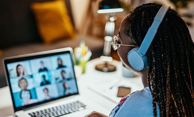 Woman at laptop on zoom call with nine people
