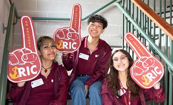 Orientation leaders smiling while holding up foam fingers