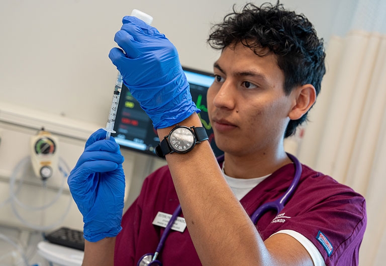Nursing student using syringe