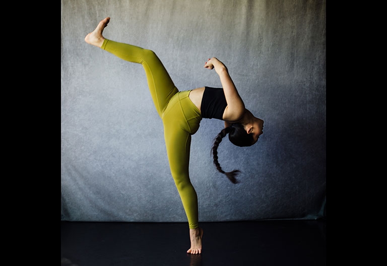 Dancer in extreme pose with leg high up in the air