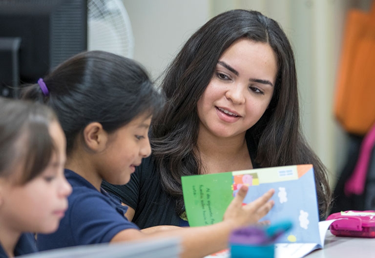 Elisa Rivera, education student, working on reading with an elementary school child