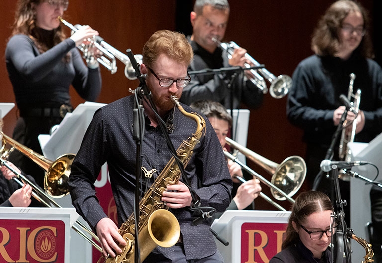 Jazz ensemble performing on stage, with saxophonist up front