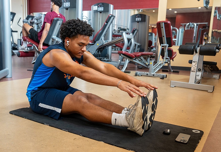 Student stretching in weight room