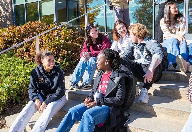 Students sitting on building's outside steps