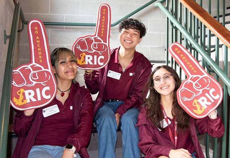 Students smiling wearing foam fingers