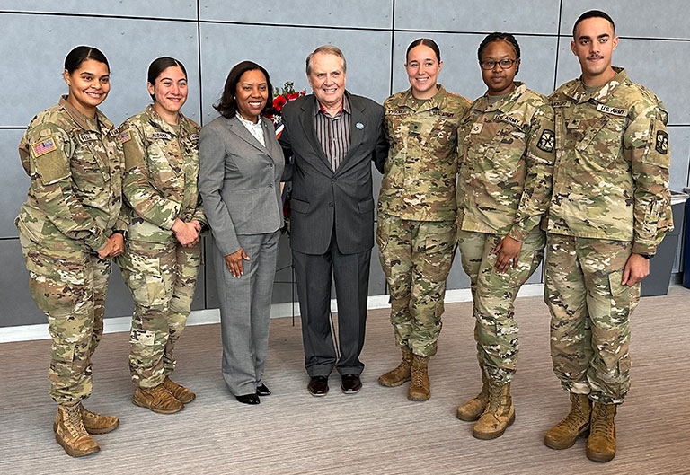President Warner with veteran students in uniform on veterans day