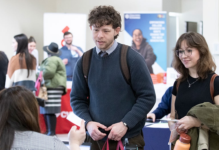 Students meeting and getting the card of an employer at an internship fair