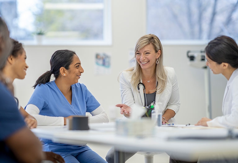 Medical professionals talking around a table