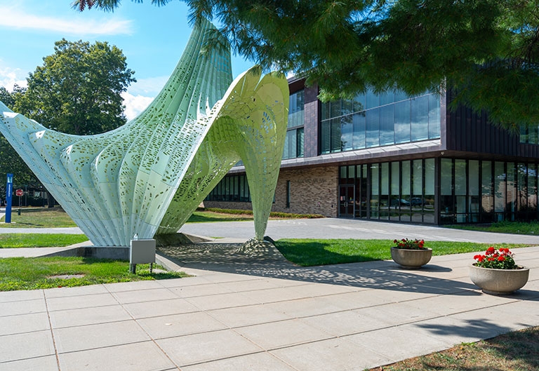 Large, green sculpture outside of Alex and Ani Hall