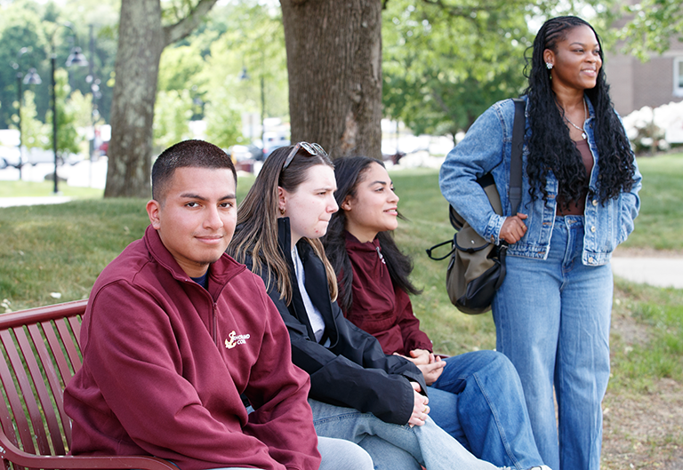 Diverse group of students sitting and standing by quad
