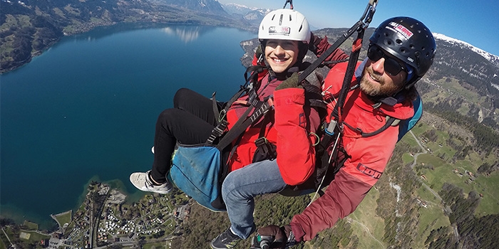Joshua (left) paraglides in Interlaken, Switzerland