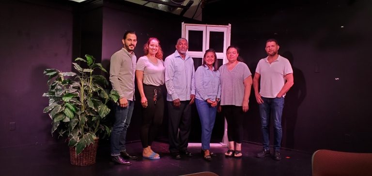 The cast of the play "Disproportionate Impact" stands onstage at Teatro ECAS