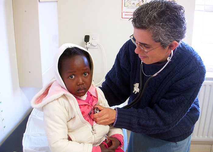 Prof. Kutenplon at clinic in Lesotho treating a pediatric patient