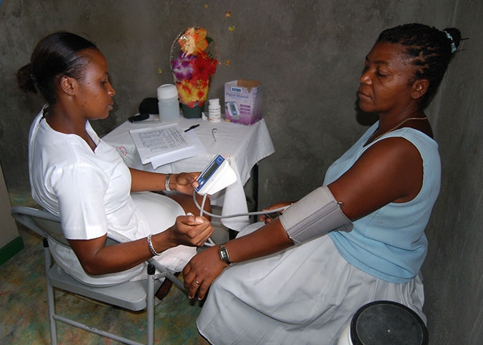 Nurse takes villager's blood pressure