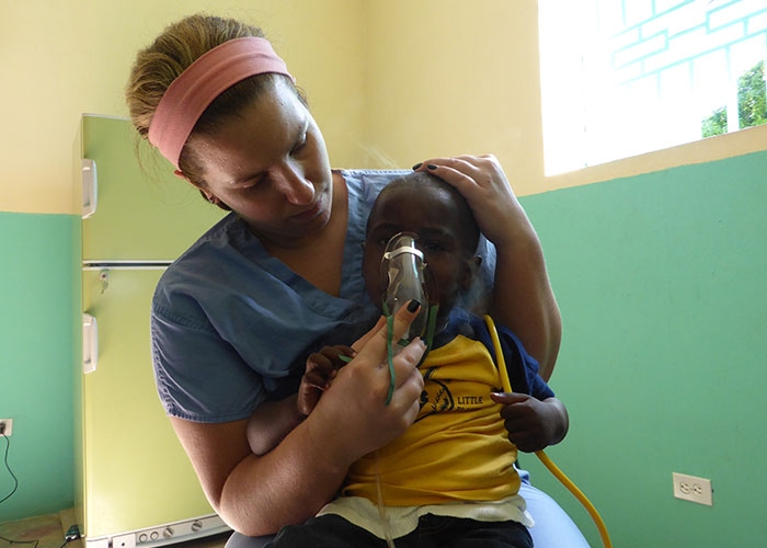 Katie Cherenzia gives oxygen to a little child at the clinic