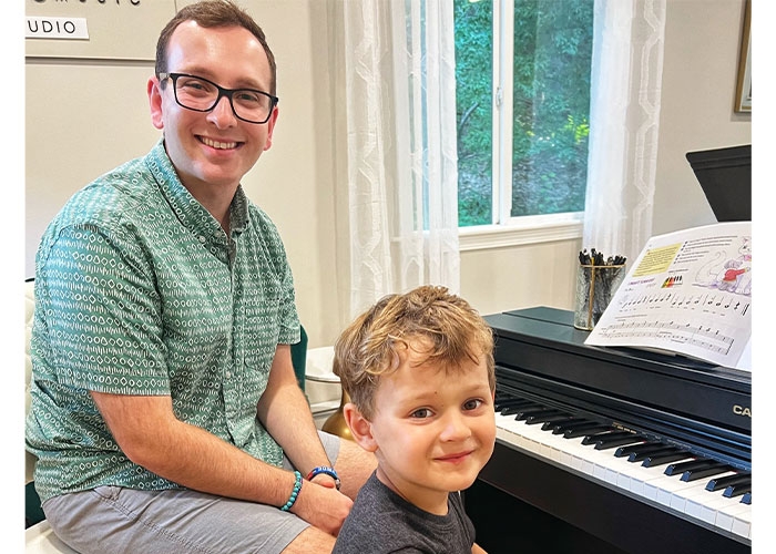 Alex Celico teaches piano to a youngster