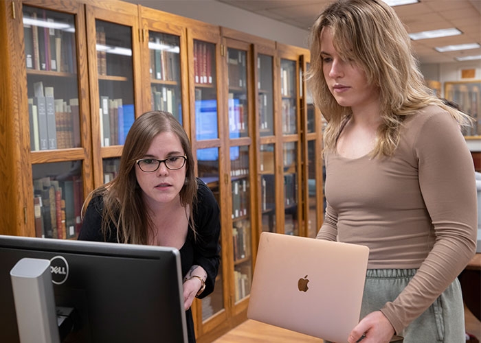 Special Collections librarian works with student on computer