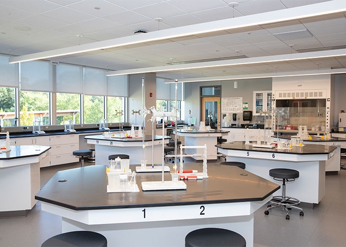 Cabinetry in the teaching labs with black, sleek tabletops and stools