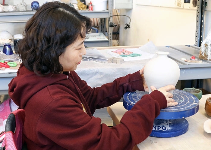Liping Zhang working at pottery wheel