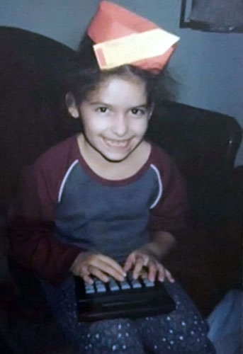Angeliz as a child playing with a calculator