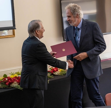 President Warner bestowing an award to a faculty member