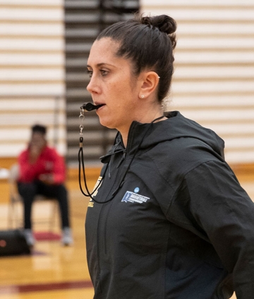 Jenna Cosgrove, basketball coach on court with whistle in her mouth