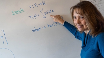 Math Professor Lisa Humphreys at white board writing equations