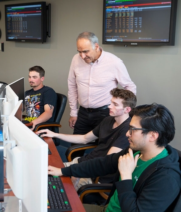 Students with professor at computers in finance lab