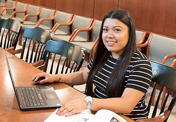 Miriam Contreras Morales sitting in a meeting room at a laptop