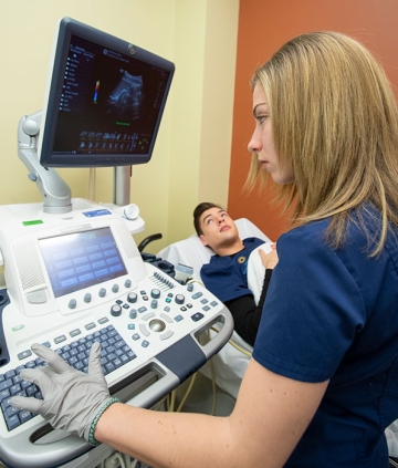 Medical imaging student working with equipment and patient