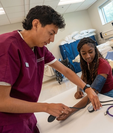 Nursing student taking a person's blood pressure