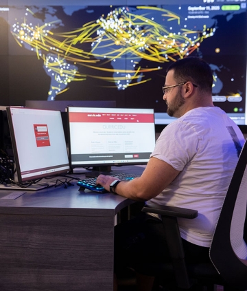 Student working at monitors in the cyber range classroom.