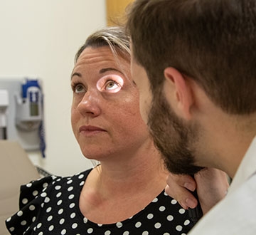 Nursing student looking into patient's eyes