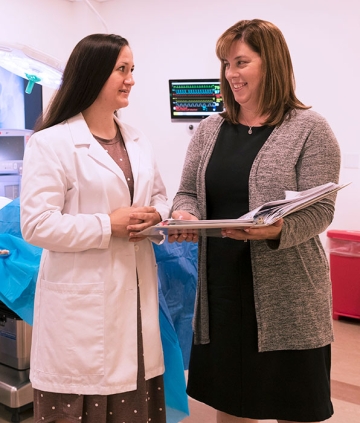 Kara Misto talking with a student, looking at a clipboard