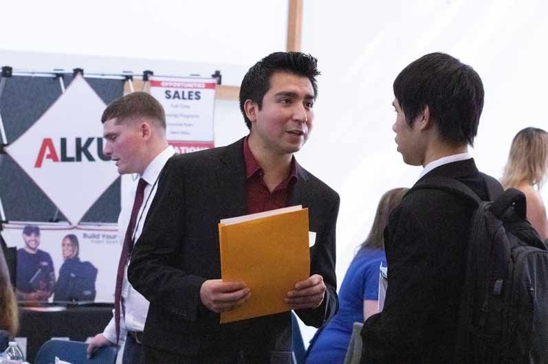 student asking questions at a trade booth