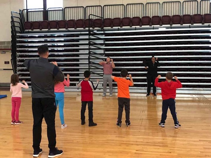 Physical Education students teaching elementary school students in gym 