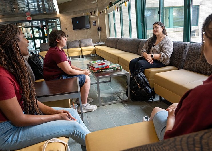 Student residence talking in common area of Sweet Hall