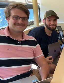 Management students working happily together at table with laptops