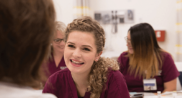 Nurse in a class room smiling