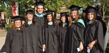 Graduate students on campus in their caps and gowns for commencement