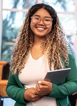 Latina high school student smiling, holding tablet