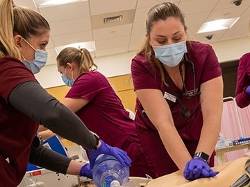 Nursing students resuscitating a mannequin