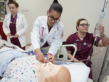 Three nursing students working on a mannequin
