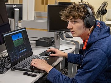 Student working on digital project, at laptop