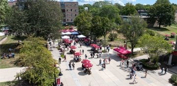 Campus quad with umbrellas and people walking