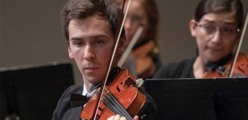 Male violinist from RIC Symphony Orchestra playing