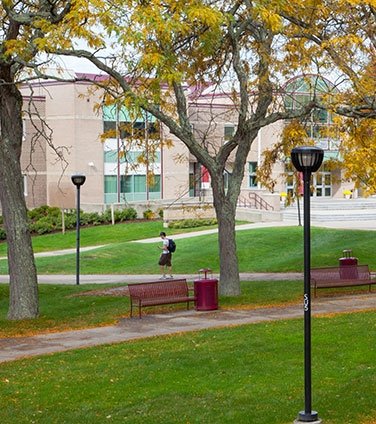 A person crossing the quad on a fall day