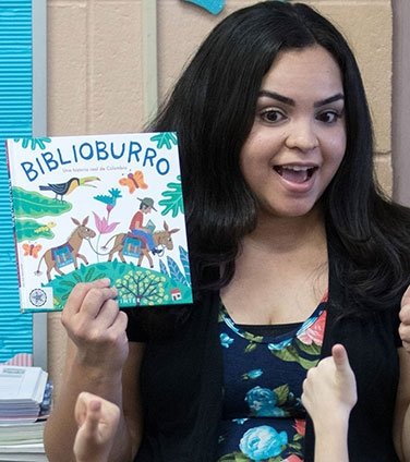 Elisa Rivera reading a book to students
