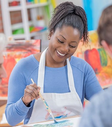 Woman smiling while painting